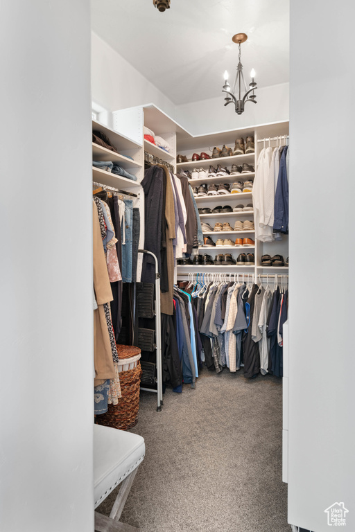 Walk in closet with carpet and a chandelier