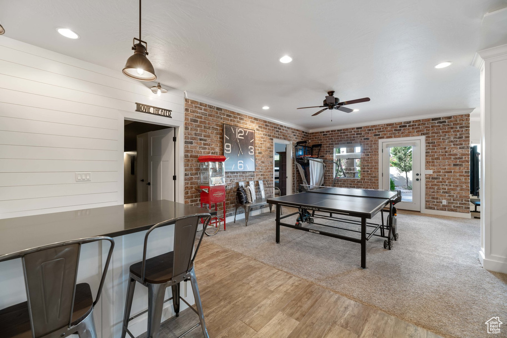 Game room with ceiling fan, brick wall, ornamental molding, light wood-type flooring, and recessed lighting