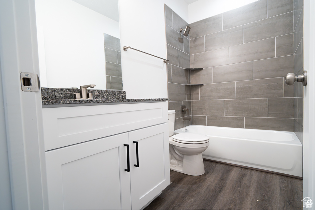 Full bathroom with vanity, wood finished floors, and tub / shower combination