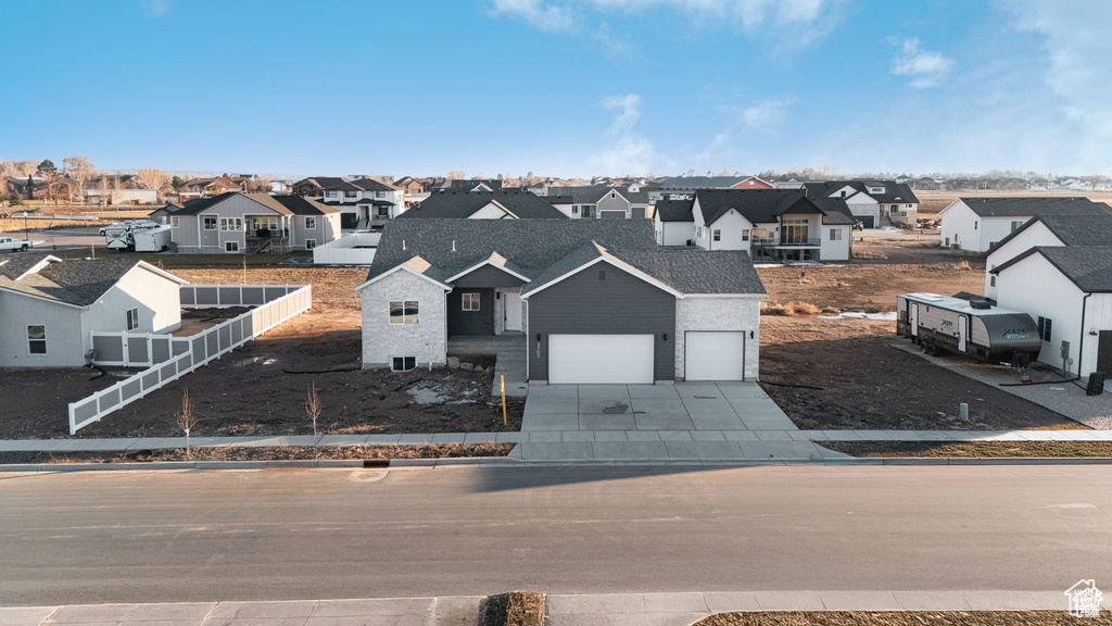 View of front of home with a residential view, driveway, and a garage
