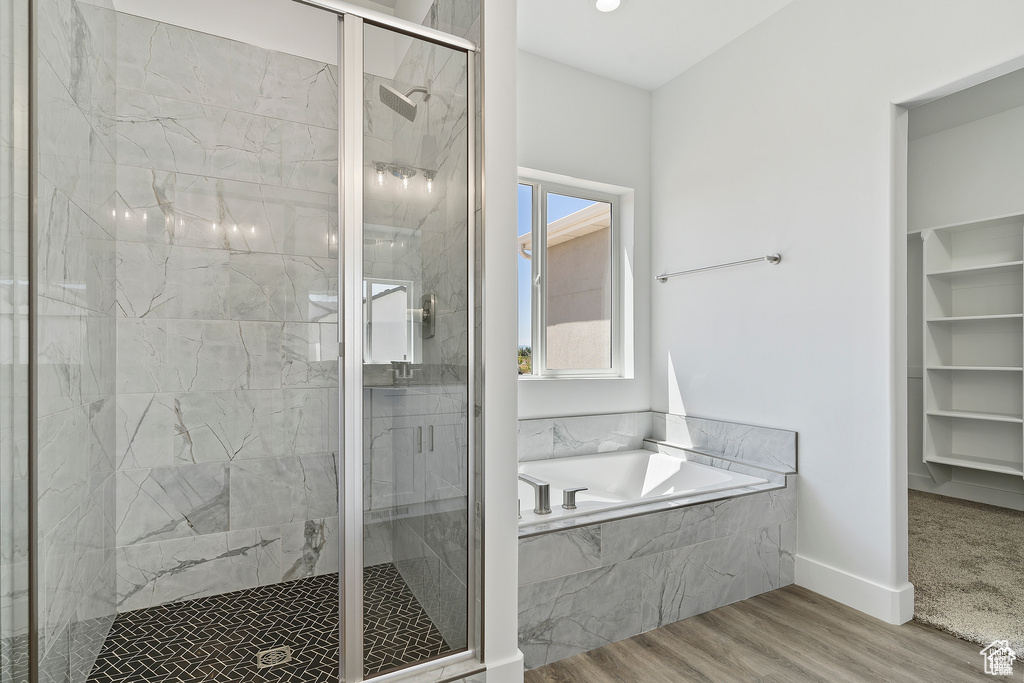 Full bath with a garden tub, a marble finish shower, and wood finished floors