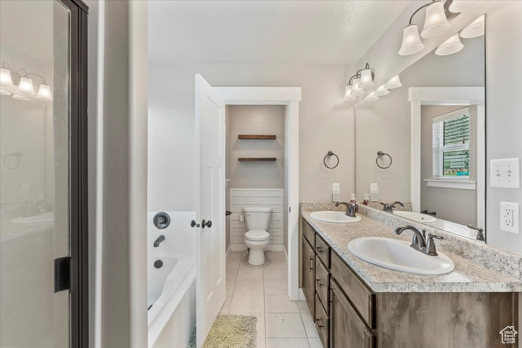 Full bathroom featuring tile patterned floors, double vanity, and a bathtub