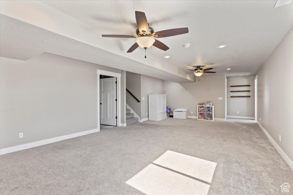 Unfurnished living room featuring carpet floors, ceiling fan, stairway, and recessed lighting