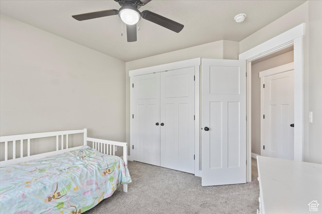 Bedroom featuring light carpet, a closet, and ceiling fan