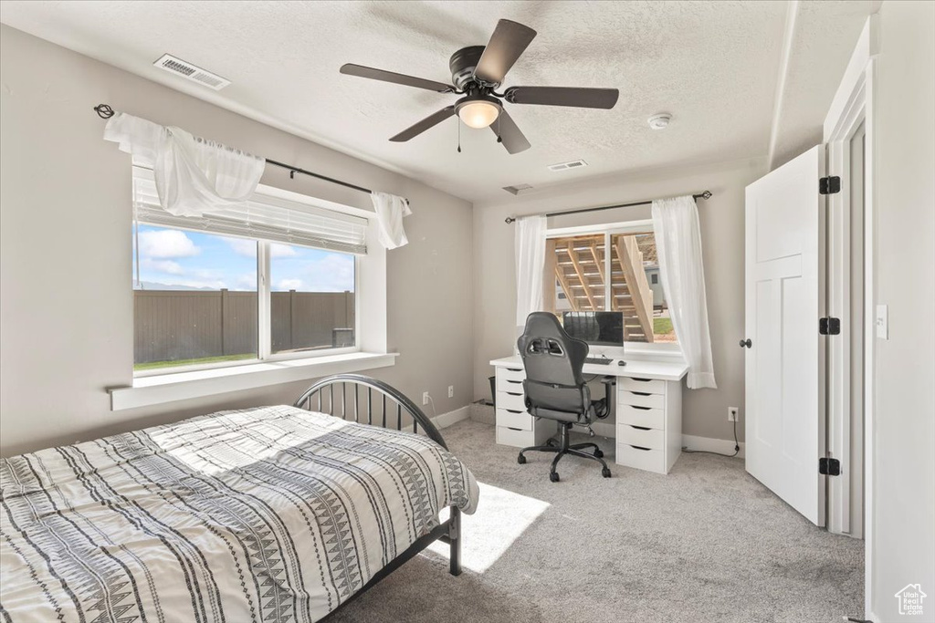 Bedroom featuring carpet flooring, a textured ceiling, and ceiling fan