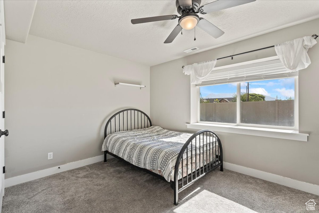 Carpeted bedroom with baseboards and ceiling fan
