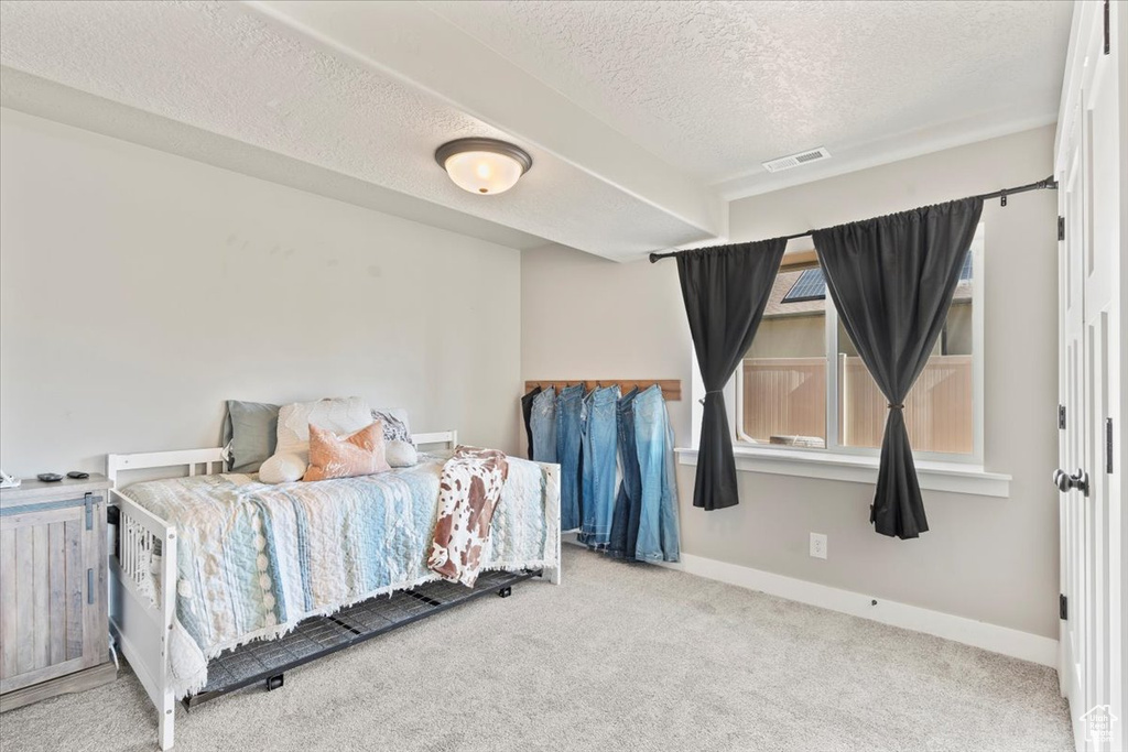 Bedroom with a textured ceiling and carpet floors