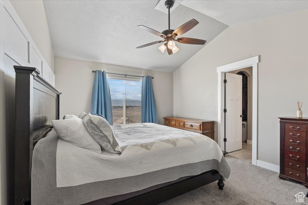 Bedroom with vaulted ceiling, light colored carpet, and ceiling fan