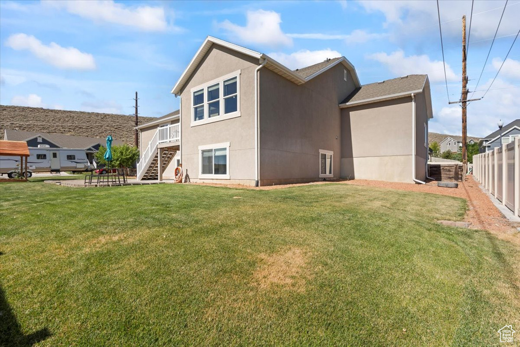 Rear view of property featuring stucco siding and stairway