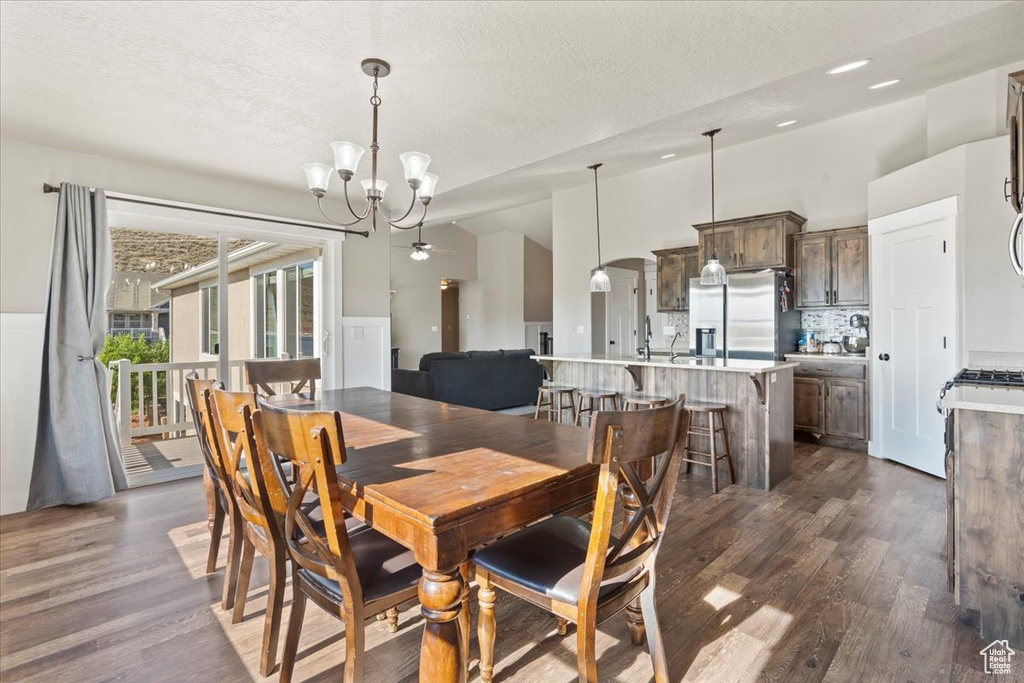 Dining room featuring a chandelier, dark wood-style floors, and a textured ceiling