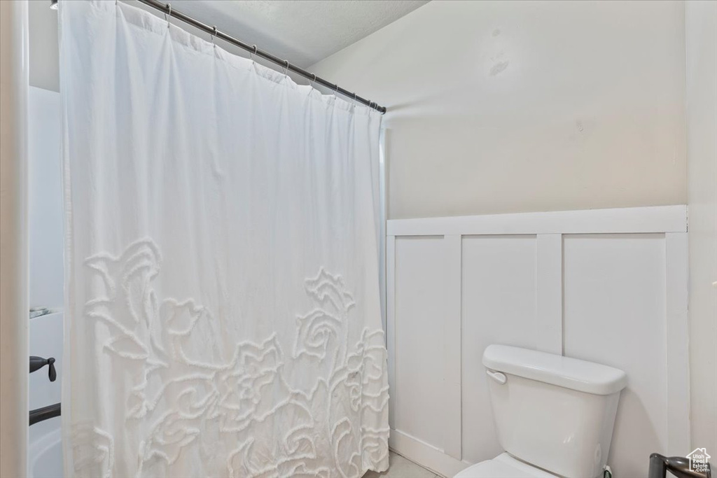 Full bathroom with toilet and shower / bathtub combination with curtain