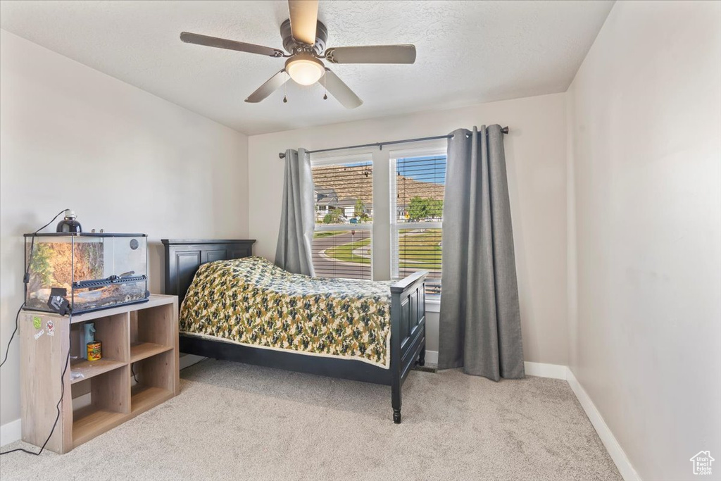 Bedroom featuring light colored carpet and a ceiling fan