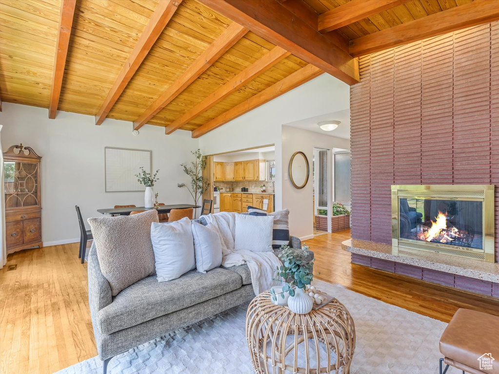 Living room with light wood finished floors, a fireplace, and wood ceiling