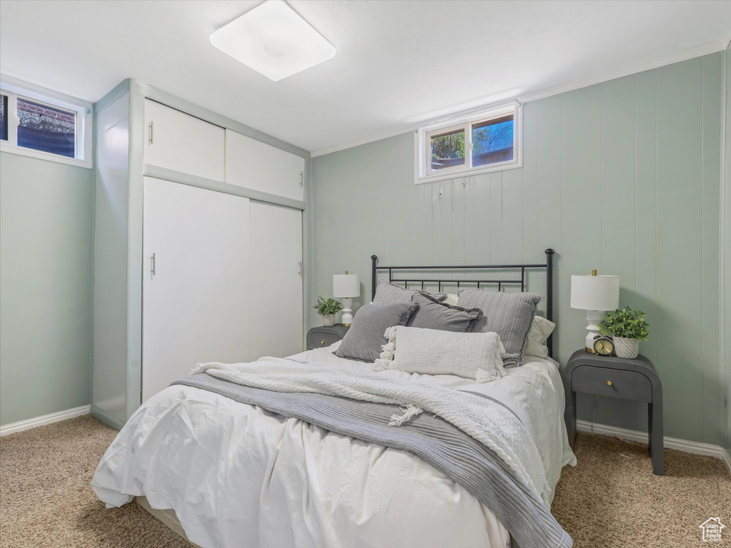 Bedroom with light carpet and a closet
