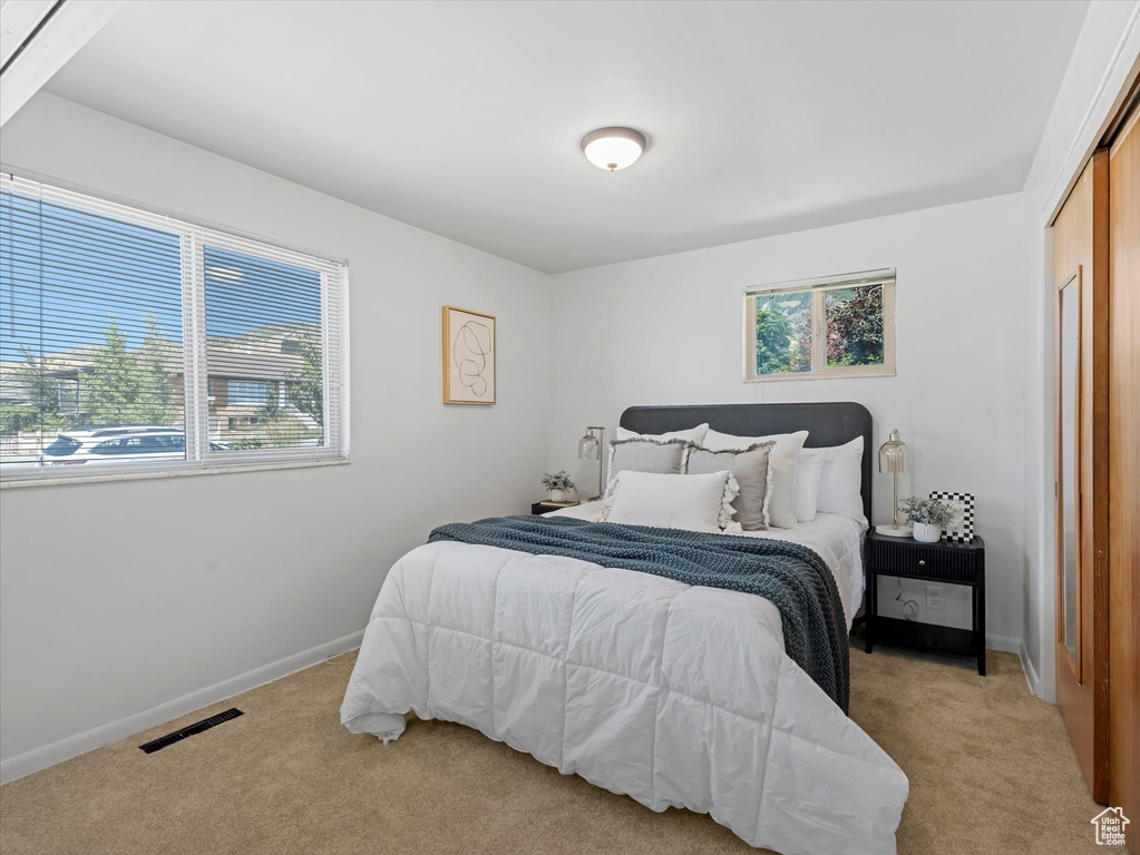 Bedroom featuring light carpet and a closet