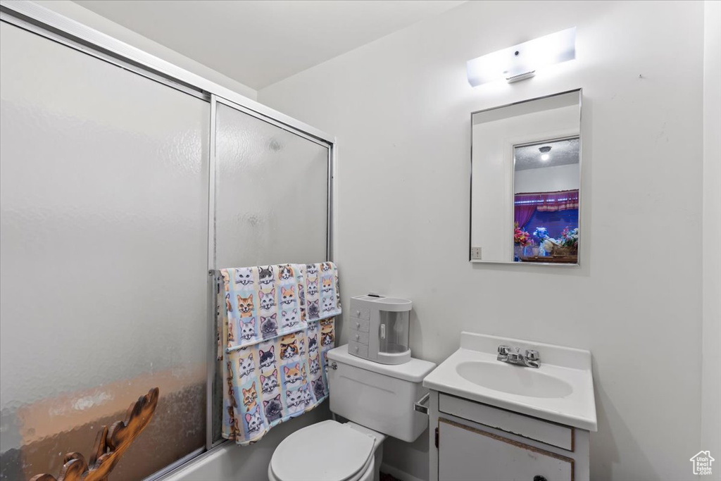 Full bath featuring vanity and bath / shower combo with glass door