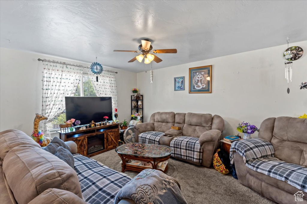 Living room with carpet and a ceiling fan