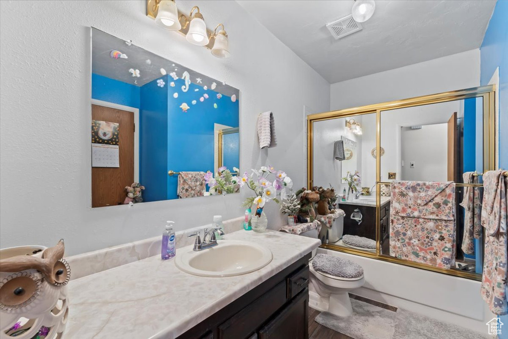 Full bath featuring vanity and bath / shower combo with glass door