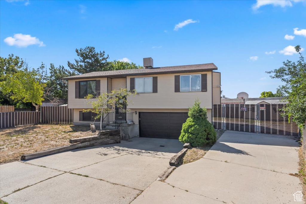 Bi-level home featuring concrete driveway and a garage