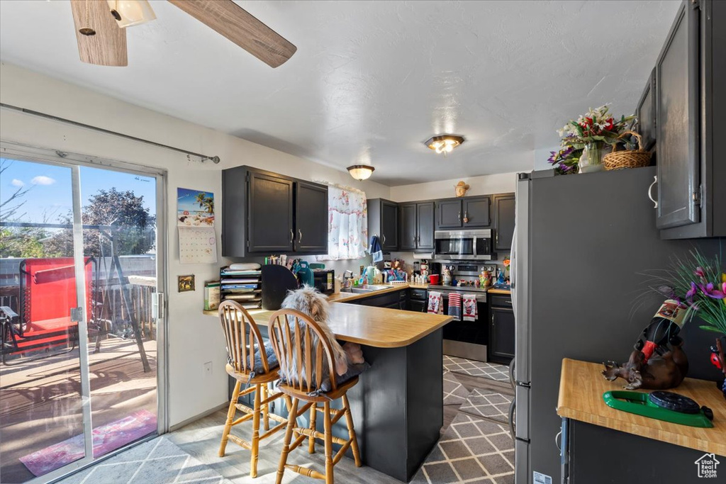 Kitchen with stainless steel appliances, a peninsula, and a kitchen bar