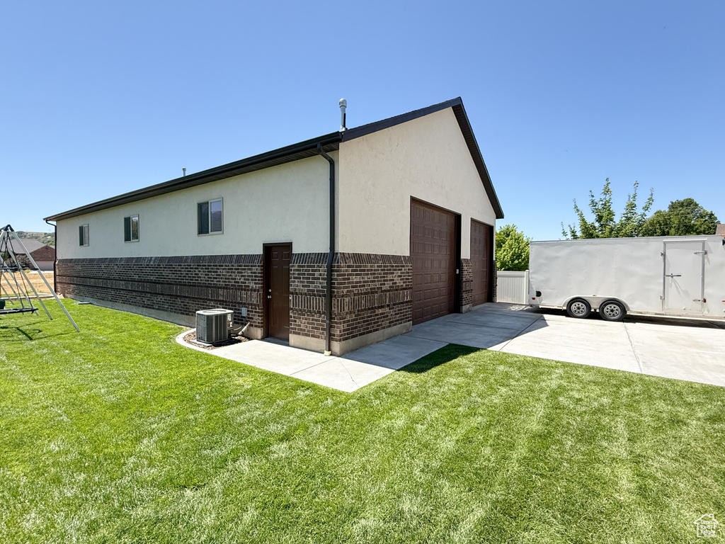 Rear view of house featuring brick siding, stucco siding, and a garage