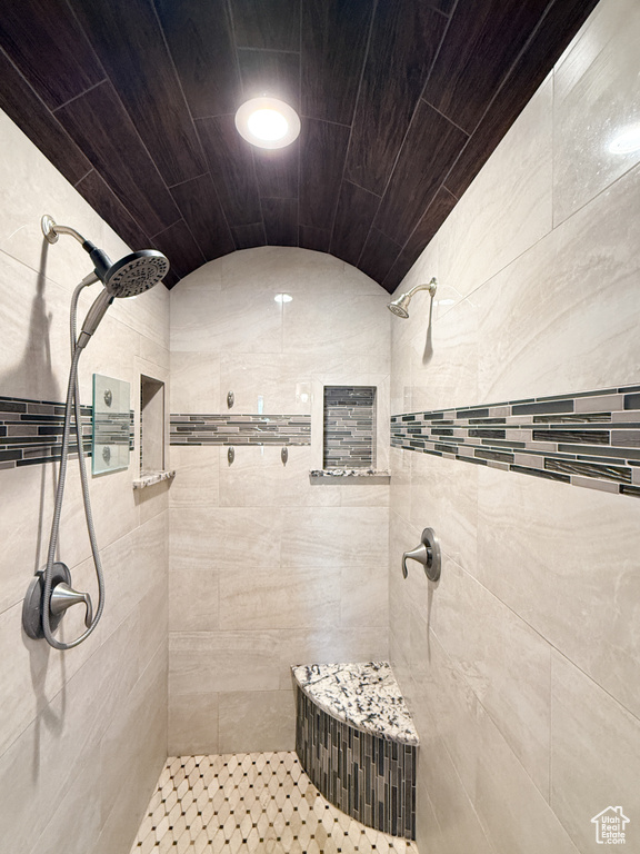 Bathroom with tiled shower and vaulted ceiling