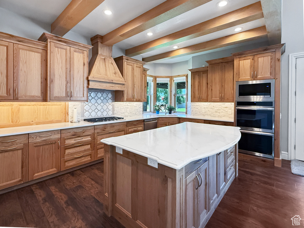 Kitchen featuring custom exhaust hood, stainless steel appliances, beam ceiling, dark wood-style flooring, and recessed lighting
