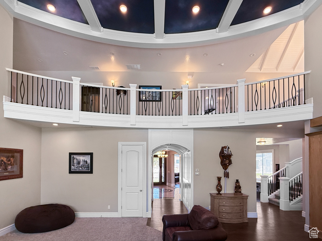 Community lobby with a towering ceiling, recessed lighting, beamed ceiling, and stairway