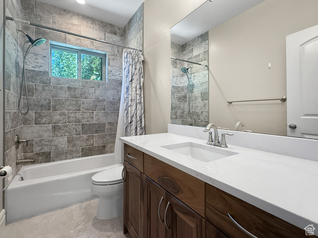 Full bath featuring vanity, shower / tub combo with curtain, and marble look tiles