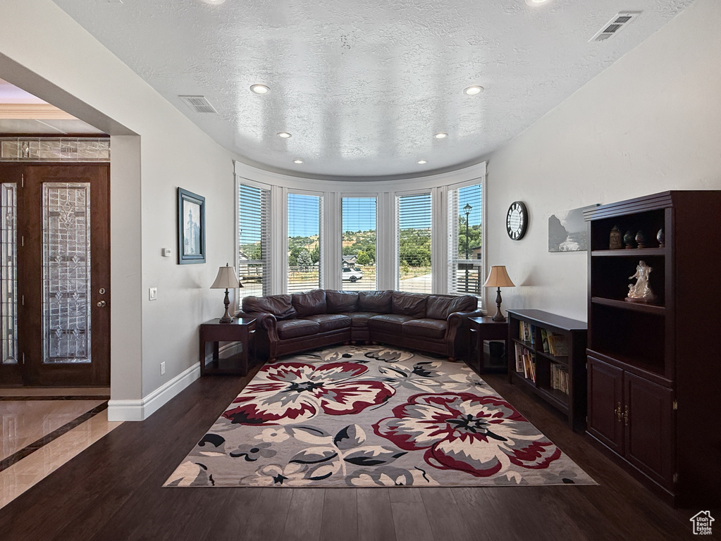 Living room featuring wood finished floors, a textured ceiling, and recessed lighting