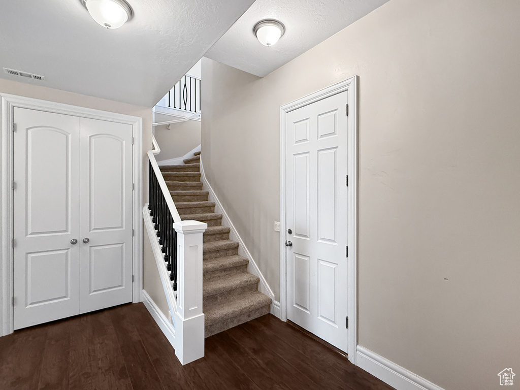 Staircase with wood finished floors and baseboards