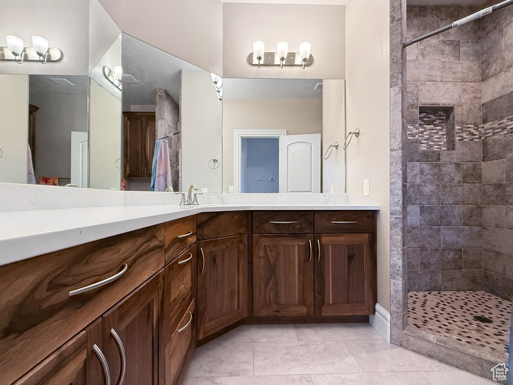 Bathroom featuring a tile shower and vanity