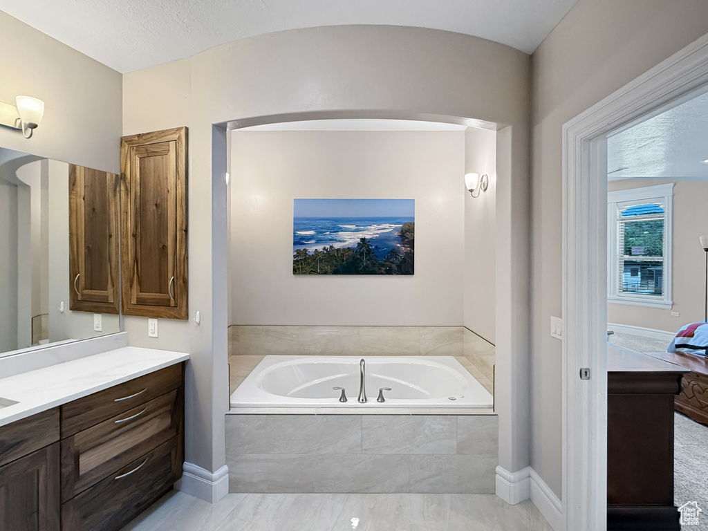 Full bathroom featuring vanity, a bath, and connected bathroom