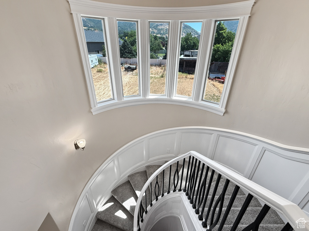 Stairway featuring a decorative wall and wainscoting