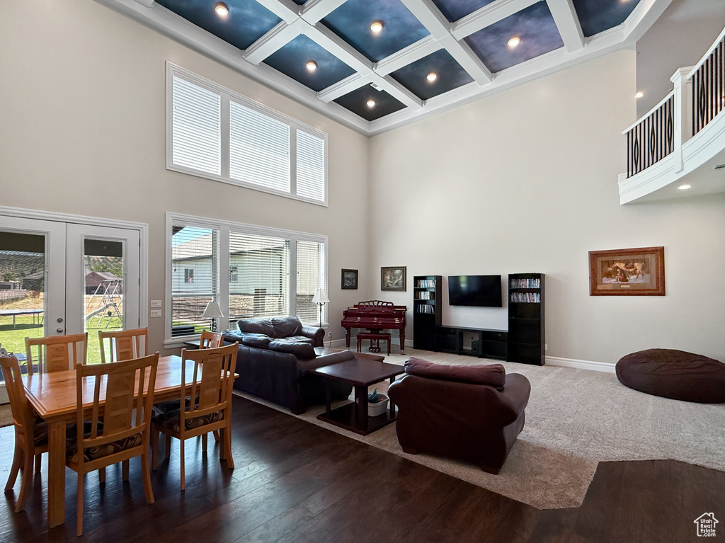Living area featuring a high ceiling, coffered ceiling, french doors, beamed ceiling, and dark wood-style flooring