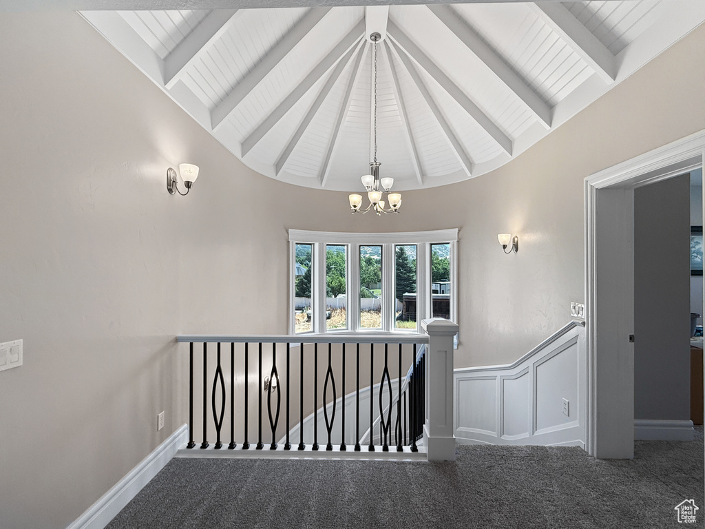 Stairway featuring carpet floors, a chandelier, and a wainscoted wall