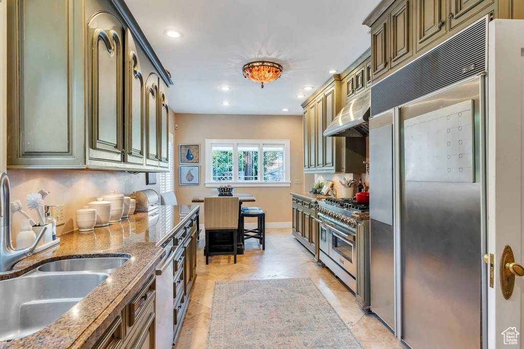 Kitchen featuring stainless steel appliances, under cabinet range hood, recessed lighting, and stone counters