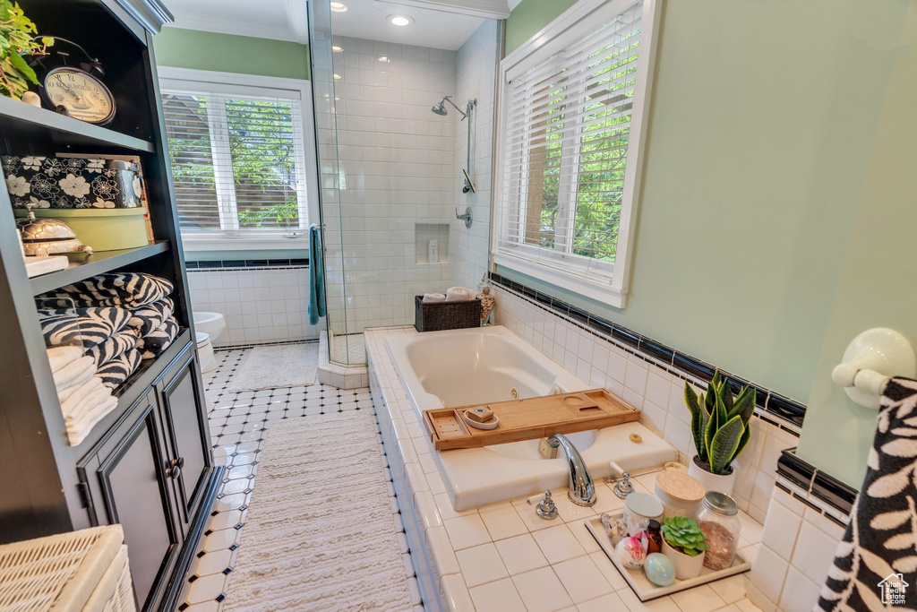 Bathroom featuring a stall shower, tile patterned floors, a jetted tub, vanity, and tile walls
