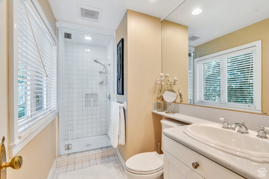 Bathroom featuring a shower stall, vanity, and tile patterned flooring