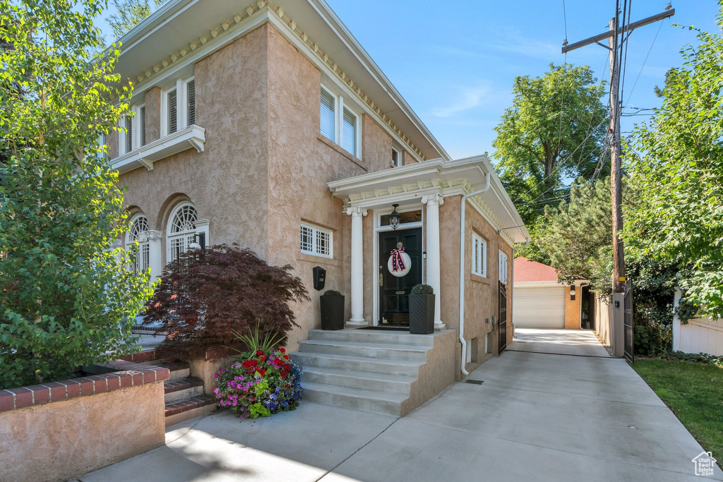 View of front of property with stucco siding and an outbuilding