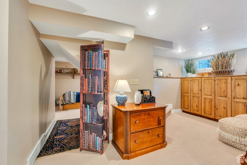 Living area with light carpet and recessed lighting
