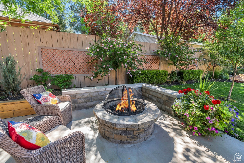 Fenced backyard featuring a fire pit and a patio