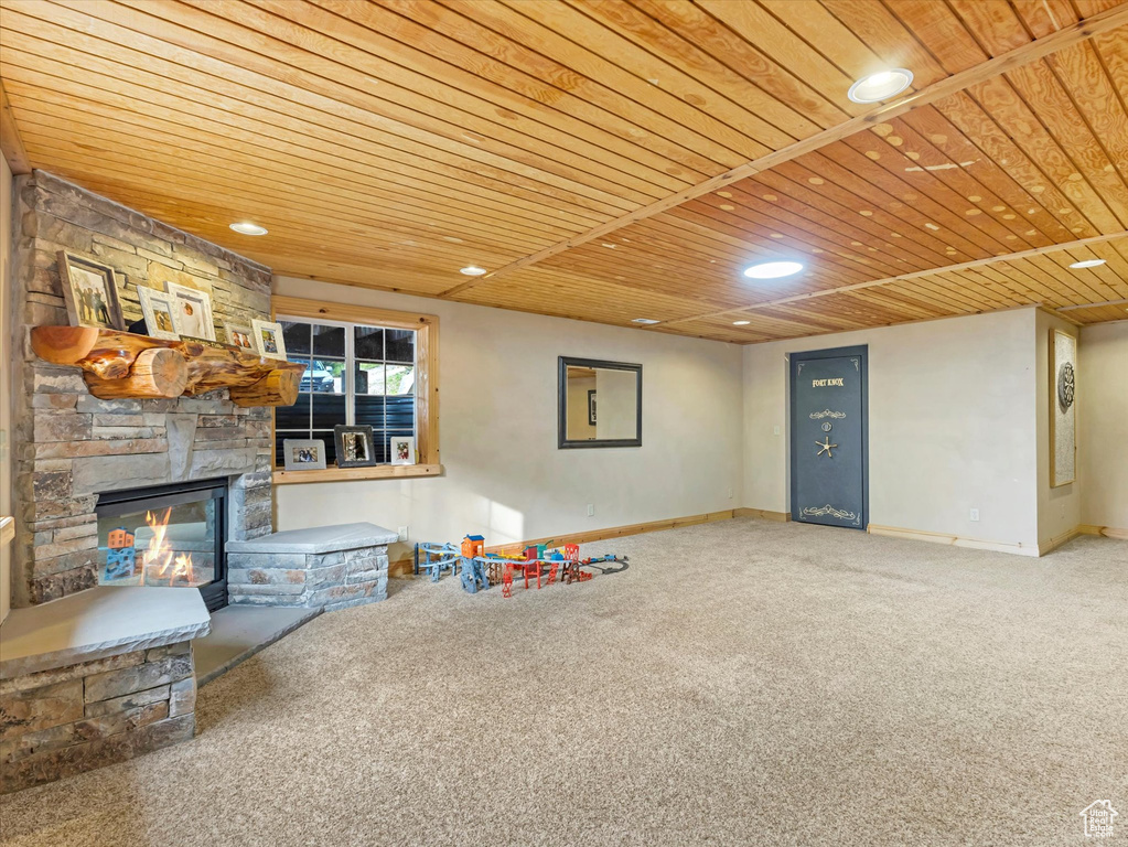 Rec room featuring wood ceiling, carpet floors, a stone fireplace, and recessed lighting