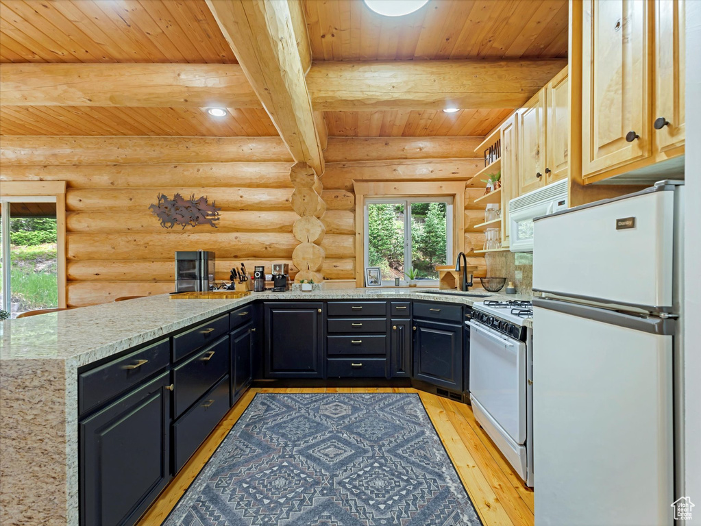 Kitchen featuring white appliances, a wooden ceiling with exposed beams, log walls, light wood-style floors, and light stone counters