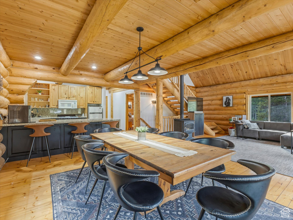 Dining space with log walls, a wood ceiling with exposed beams, stairway, light wood-type flooring, and recessed lighting