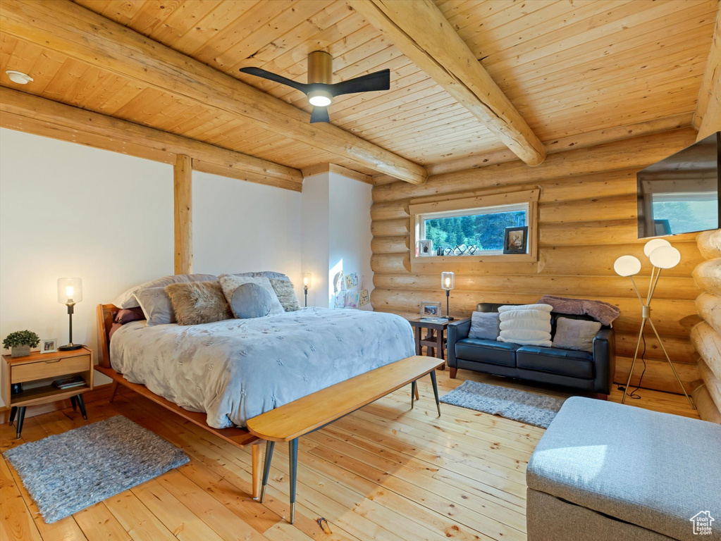 Bedroom featuring a wood ceiling with exposed beams, hardwood / wood-style floors, log walls, and multiple windows