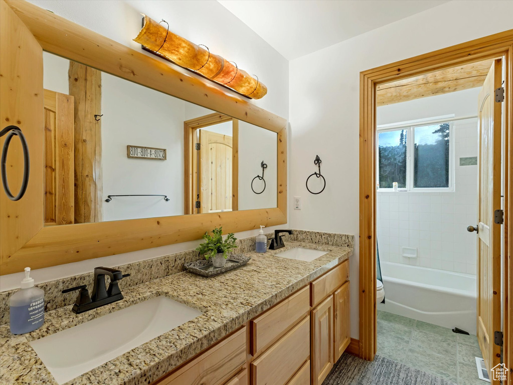 Bathroom featuring double vanity and shower / bath combination