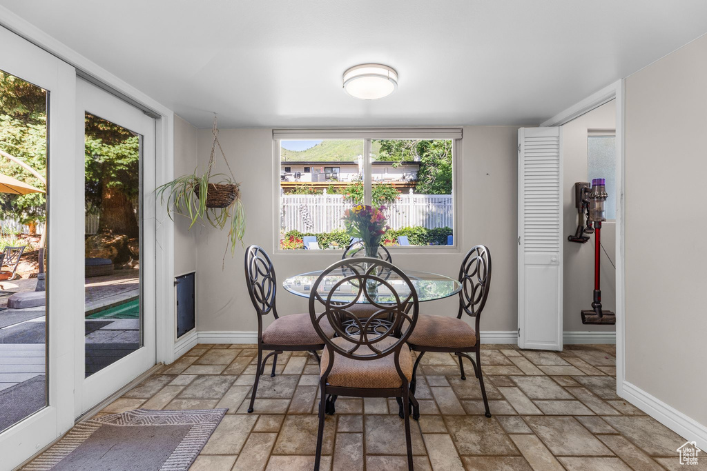 Dining space with stone tile flooring and baseboards