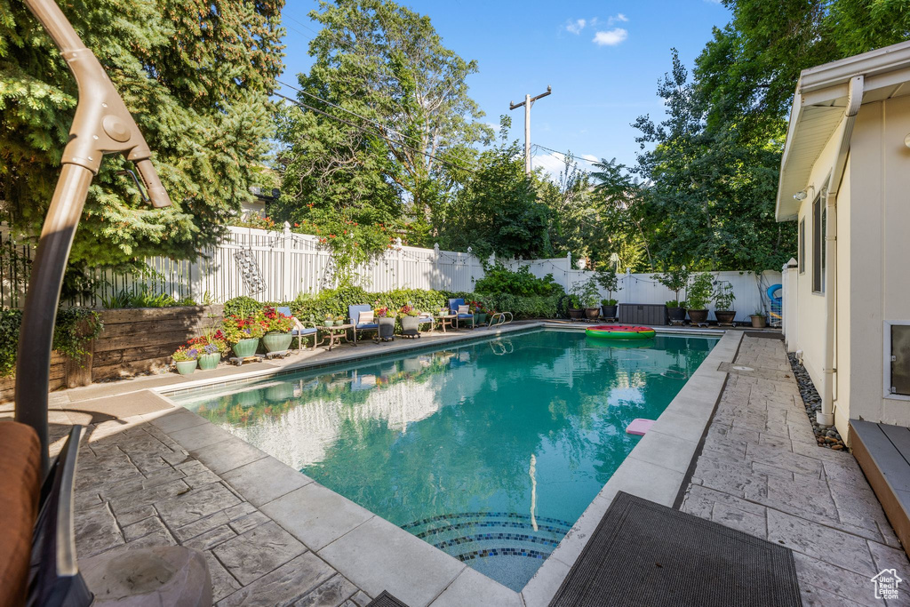 View of swimming pool featuring a fenced backyard and a patio
