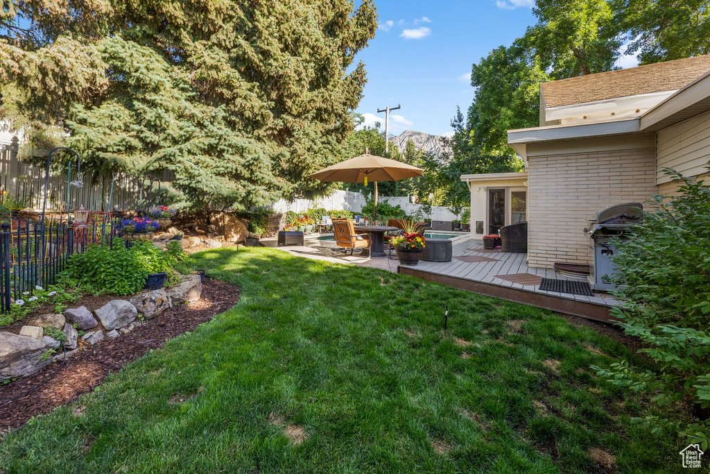 Fenced backyard featuring a deck with mountain view